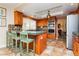 Kitchen featuring tile countertops, stainless appliances, oak cabinets, and bar seating at 8875 Tidal Bay Dr, Las Vegas, NV 89117
