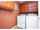 Laundry room with front loading washer, dryer, and upper cabinets at 8875 Tidal Bay Dr, Las Vegas, NV 89117