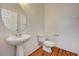 Simple powder room featuring pedestal sink, oval mirror, toilet, and tile floors at 9115 Canoga Canyon Ct # 103, Las Vegas, NV 89149