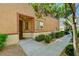 Close up of townhouse entrance featuring a covered entry, small front window and green shrubbery at 9115 Canoga Canyon Ct # 103, Las Vegas, NV 89149