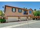 Lovely exterior view of a multi-Gathering townhouse with a terra cotta tile roof and three garages at 9115 Canoga Canyon Ct # 103, Las Vegas, NV 89149