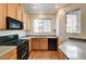 Cozy kitchen featuring wood cabinets, black appliances, and a double sink under a bright window at 9115 Canoga Canyon Ct # 103, Las Vegas, NV 89149