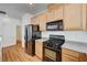 Kitchen featuring black appliances, wood cabinets, and laminate flooring at 9115 Canoga Canyon Ct # 103, Las Vegas, NV 89149