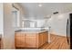 Galley kitchen featuring wood cabinetry and speckled countertops, adjacent to a spacious living area at 9115 Canoga Canyon Ct # 103, Las Vegas, NV 89149