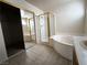 Bathroom with double mirrored closet, a shower with glass enclosure, and a garden tub at 9693 Bighorn Island Ave, Las Vegas, NV 89148