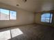 A carpeted bedroom with natural light from two windows featuring a view of the neighborhood at 9693 Bighorn Island Ave, Las Vegas, NV 89148