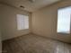 A clean bedroom with neutral walls, two windows, and tiled flooring at 9693 Bighorn Island Ave, Las Vegas, NV 89148
