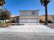 Two-story home with a wide driveway and a two-car garage under a clear, sunny sky at 9693 Bighorn Island Ave, Las Vegas, NV 89148