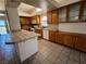 Well-lit kitchen with tiled countertops and backsplash, an island, and oak cabinets at 9693 Bighorn Island Ave, Las Vegas, NV 89148
