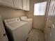 Functional laundry room with white washer and dryer, storage cabinets, and a window at 9693 Bighorn Island Ave, Las Vegas, NV 89148