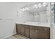 Elegant bathroom featuring double sinks, white marble counters, and wood-look flooring at 9784 Kodiak Island Ct, Las Vegas, NV 89141