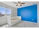 Bedroom with a white bed, a blue accent wall, a window, and neutral colored carpet at 9784 Kodiak Island Ct, Las Vegas, NV 89141