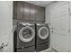 Convenient laundry room with a front-load washer and dryer and upper cabinets at 9784 Kodiak Island Ct, Las Vegas, NV 89141