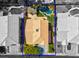 Aerial view of a backyard with a pool and patio, surrounded by lush greenery and a well-maintained roof at 9909 Masked Duck Ave, Las Vegas, NV 89117