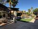 Outdoor living space with pool, waterfall, covered patio, and lush landscaping creating a private backyard oasis at 9909 Masked Duck Ave, Las Vegas, NV 89117