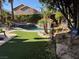 Lush backyard featuring a pool, spa, rock waterfall, and lush landscaping offers a private oasis at 9909 Masked Duck Ave, Las Vegas, NV 89117