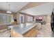 Open kitchen boasts a granite island, bright natural light, and view into the living room at 9909 Masked Duck Ave, Las Vegas, NV 89117