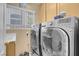 Laundry room featuring modern washer and dryer, sink, and storage cabinets at 9909 Masked Duck Ave, Las Vegas, NV 89117