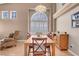 Spacious dining area with oversized window, stylish chandelier, and hardwood floors at 9909 Masked Duck Ave, Las Vegas, NV 89117