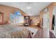 Bright main bedroom with a ceiling fan, TV, and doorway leading to a bathroom at 9909 Masked Duck Ave, Las Vegas, NV 89117