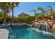 Private backyard oasis featuring a custom pool and rock waterfall at 9909 Masked Duck Ave, Las Vegas, NV 89117