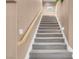 Carpeted staircase with wooden handrail and in-wall lights leading upstairs at 9909 Masked Duck Ave, Las Vegas, NV 89117