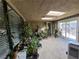 Enclosed sunroom filled with numerous plants, skylights, and an air conditioning unit at , Las Vegas, NV 89128