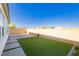 A grassy backyard enclosed by a block wall with views of distant homes at , Las Vegas, NV 89166