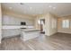 Open-concept kitchen with gray cabinets, island, stainless appliances, and wood-look flooring at , Las Vegas, NV 89166