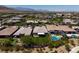 Aerial view of a backyard with lush green grass, a pool, and a putting green in a community at 10349 Bressana Dr, Las Vegas, NV 89135