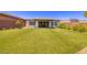 Lush backyard features artificial turf, modern desert landscaping, and a covered patio perfect for entertaining at 10349 Bressana Dr, Las Vegas, NV 89135