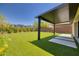 Beautiful backyard featuring a covered patio area, well-maintained artificial turf, and desert landscaping at 10349 Bressana Dr, Las Vegas, NV 89135