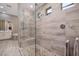 Modern bathroom with a glass-enclosed shower featuring decorative tiling at 10349 Bressana Dr, Las Vegas, NV 89135