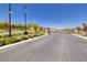A straight street view of the community entrance with security cameras and landscaping at 10349 Bressana Dr, Las Vegas, NV 89135
