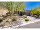 Charming single-story home with a well-manicured lawn, stone accents, and an attached two-car garage at 10349 Bressana Dr, Las Vegas, NV 89135