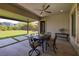 Covered patio seating area with ceiling fan, dining table and chairs, with a green lawn at 10349 Bressana Dr, Las Vegas, NV 89135