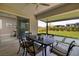 Covered patio area with outdoor dining table, chairs, and a beautiful view of the manicured backyard at 10349 Bressana Dr, Las Vegas, NV 89135