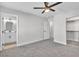 View of bedroom showcasing gray carpet, bathroom doorway, walk-in closet, and ceiling fan at 10373 Midnight Iris St, Las Vegas, NV 89183
