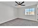 Bright bedroom featuring gray carpet, white trim, and a window with a neighborhood view at 10373 Midnight Iris St, Las Vegas, NV 89183