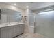 Well-lit bathroom featuring a double sink vanity, ample counter space, and a glass-enclosed shower at 10630 Adobe Ranch St, Las Vegas, NV 89141