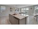 Spacious kitchen with a center island, stainless steel appliances, and ample natural light from many windows at 10630 Adobe Ranch St, Las Vegas, NV 89141