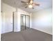 Bedroom with gray carpet, white walls, ceiling fan and mirrored closet doors at 11219 Playa Bonita Ave, Las Vegas, NV 89138