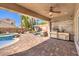 An inviting covered patio features an outdoor kitchen and seating area for entertaining guests and relaxing at 11219 Playa Bonita Ave, Las Vegas, NV 89138