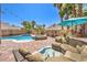 Backyard oasis featuring a pool, hot tub, and comfortable outdoor seating area at 11219 Playa Bonita Ave, Las Vegas, NV 89138