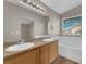 Bright bathroom featuring double sinks, granite countertops, a large mirror, and a soaking tub at 1553 Ivygate Ave, Las Vegas, NV 89183