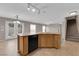 Open kitchen featuring wood cabinets, black appliances, tile flooring, granite countertops and adjacent staircase at 1553 Ivygate Ave, Las Vegas, NV 89183