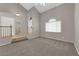 Spacious living room featuring vaulted ceiling, neutral carpet and steps leading to another level at 1553 Ivygate Ave, Las Vegas, NV 89183