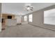 Open floor plan with spacious living room flowing into the kitchen and featuring neutral carpet and tile floors at 1553 Ivygate Ave, Las Vegas, NV 89183