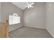 Spacious living room with neutral carpet, vaulted ceiling, and arched window providing natural light at 1553 Ivygate Ave, Las Vegas, NV 89183