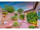Landscaped backyard features desert landscaping, pavers, and colorful sky at 1643 Silver Slipper Ave, Henderson, NV 89002
